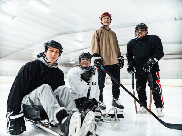 Mature Disabled Latin woman with her family and friends  practising sledge hockey stock photo