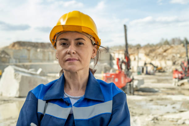 Mature female builder in hardhat looking at camera stock photo
