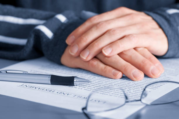 Mature hands with last will and testament stock photo