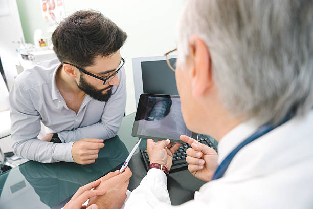 Mature Male Doctor Using A Digital Tablet For His Diagnosis. stock photo