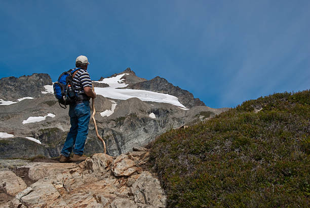 Mature Male Hiking on Sahale Arm This mature male hiker was hiking up Sahale Arm near Cascade Pass in North Cascades National Park, Washington State, USA. jeff goulden north cascades national park stock pictures, royalty-free photos & images