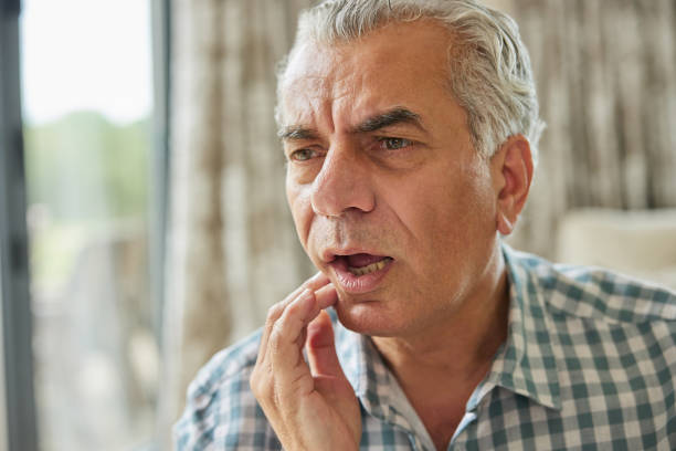 Mature Man At Home Suffering From Pain With Toothache stock photo