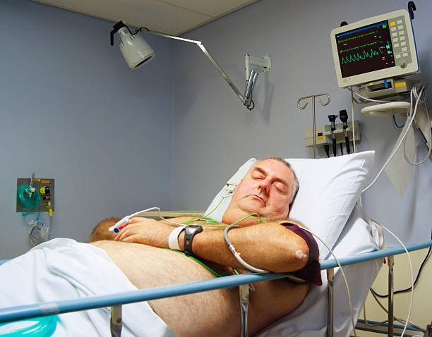 Mature man in hospital bed being monitored for Atrial Fibrillation stock photo