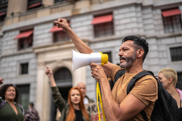 Mature man leading a demonstration using a megaphone stock photo