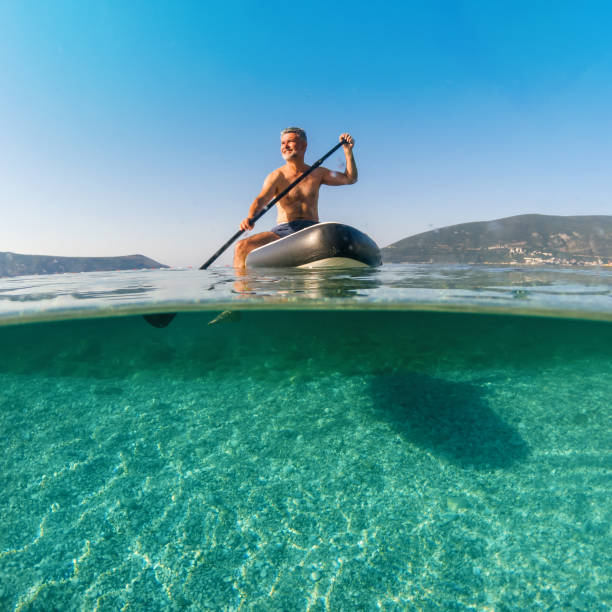 Mature man on a paddleboard on the sea in summer stock photo
