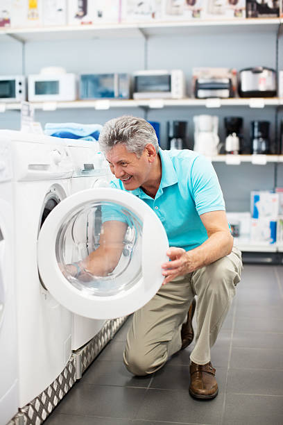 homme mature magasinant pour une machine à laver - programmer machine à laver photos et images de collection