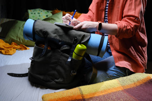 Mature person is packing big rucksack for hiking stock photo