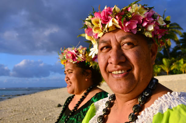 Mature Polynesian Pacific Island Women Portrait of two happy smily mature Polynesian Pacific islanders women on tropical beach with palm trees in the background. pacific islands stock pictures, royalty-free photos & images