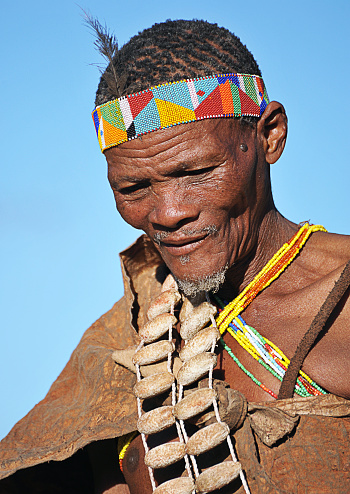 Mature San bush man portrait, Makgadikgadi Pans, Botswana, Southern Africa. The San are an ancient indigenous tribal people who inhabited much of southern Africa and although few in number today remain proud of their culture, ancestry and traditional ways of dress, customs and behaviour that included subsistence hunting and foraging
