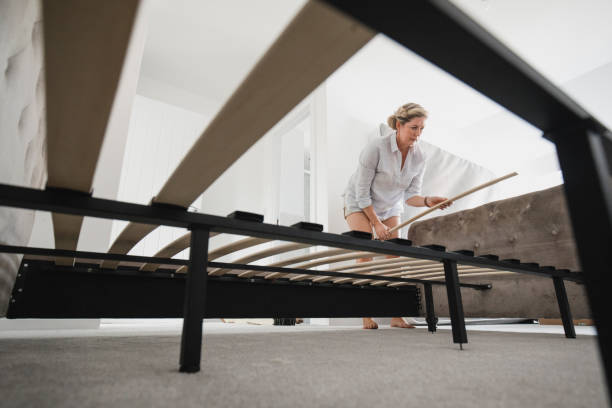 Mature Woman Building Bed in New Home stock photo