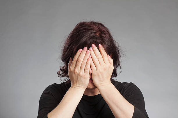 Mature woman covering eyes stock photo