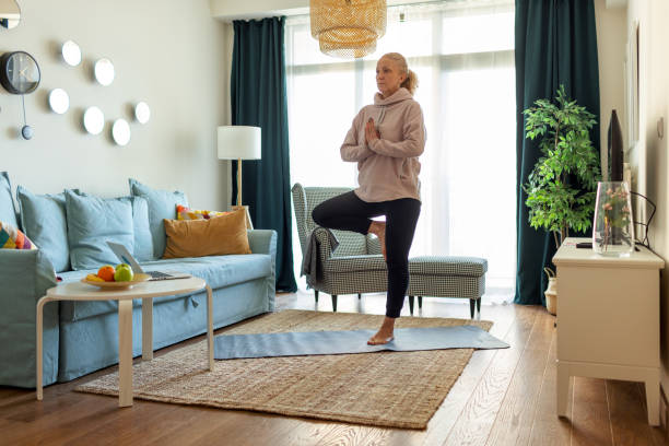 Mature Woman Doing Her Morning Yoga Exercises In The Living Room stock photo