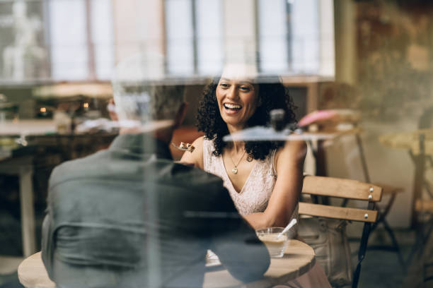 Mature woman laughing with her husband inside of a cafe stock photo