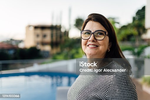 istock Mature woman looking to the side in front a swimming pool 1314103366
