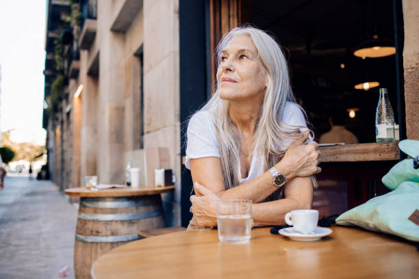 Mature woman on a journey enjoying at the cafe stock photo