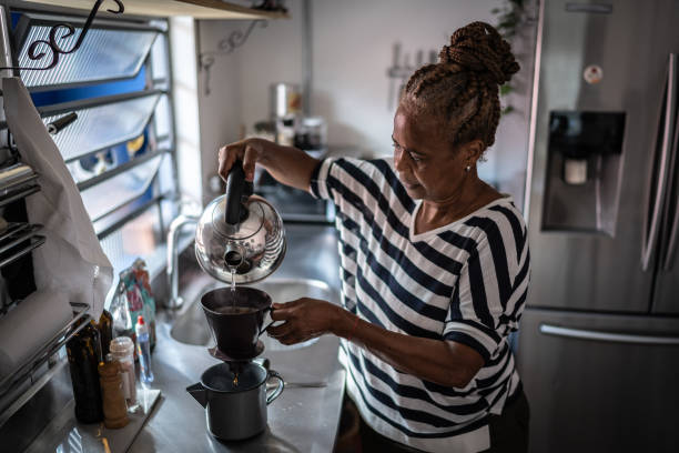 mature woman preparing coffee at home - cafe brasil imagens e fotografias de stock