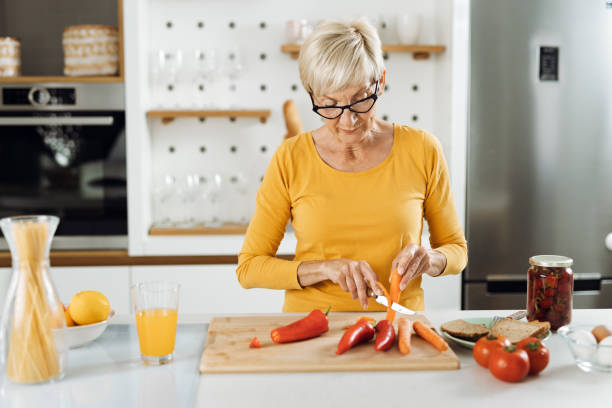 Mature woman preparing healthy food in the kitchen stock photo