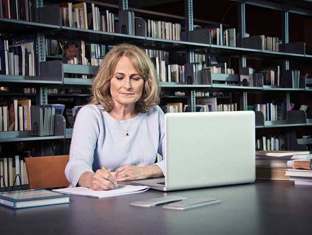 Mature Woman With Laptop Working On Something stock photo