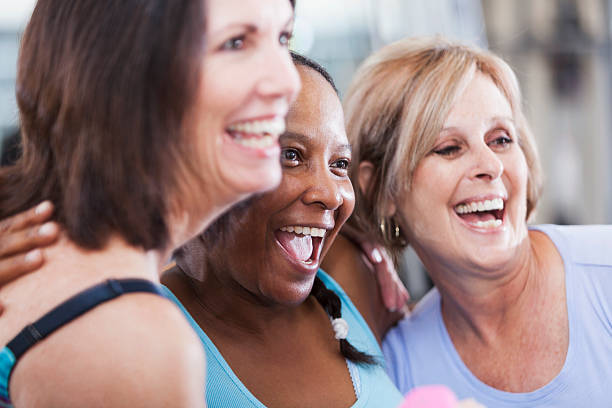 Mature women at the gym Multi-ethnic group of mature women (50s) exercising in gym.  Focus on African American woman. 50 59 years stock pictures, royalty-free photos & images