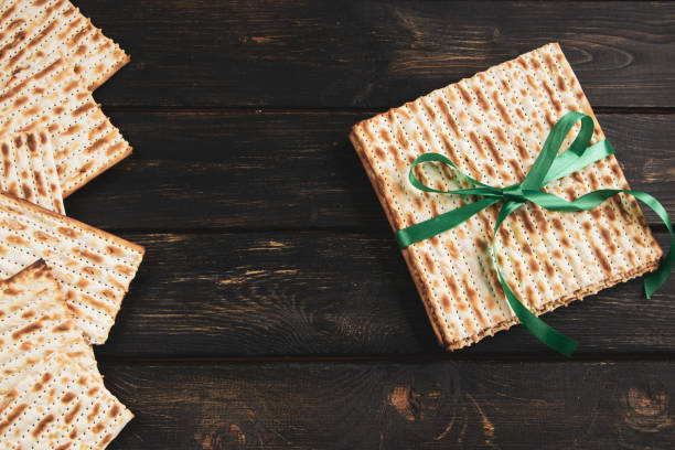 Matzah background. Happy Passover. Traditional Jewish regilious holiday Pesach. Matzo bread on a dark wooden table. stock photo