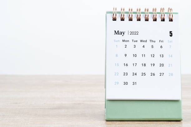 may 2022 desk calendar on wooden background. - mei stockfoto's en -beelden
