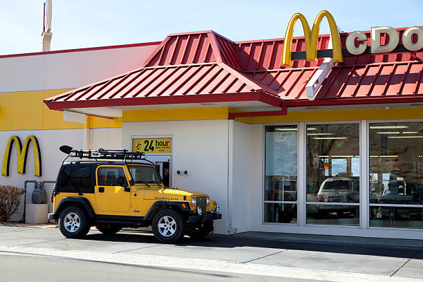 Mcdonalds drive thru service Salt Lake City, USA - February 26, 2013: Mcdonalds Drive thru service is amount one of the popular service in fast food chain restuarants, many stores open 24 hours. A yellow jeep pick up order at the drive thru window. drive thru queue stock pictures, royalty-free photos & images