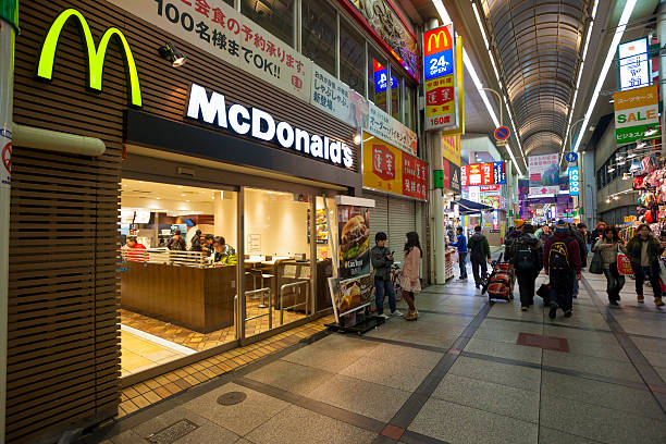 McDonalds Restaurant in a shopping arcade, Umeda, Osaka Osaka, Japan - February 6, 2012: McDonalds Restaurant in a shopping arcade in Umeda, Osaka. People can be seen walking through the arcade and sitting inside the restaurant. mcdonalds japan stock pictures, royalty-free photos & images