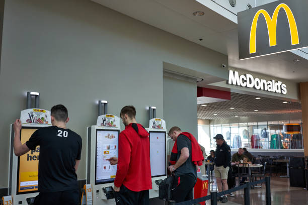 McDonald's Self Service Kiosks Portland, OR, USA - Feb 23, 2020: People using the self service kiosks to place their orders at a McDonald's Restaurant in Portland International Airport. chain store stock pictures, royalty-free photos & images