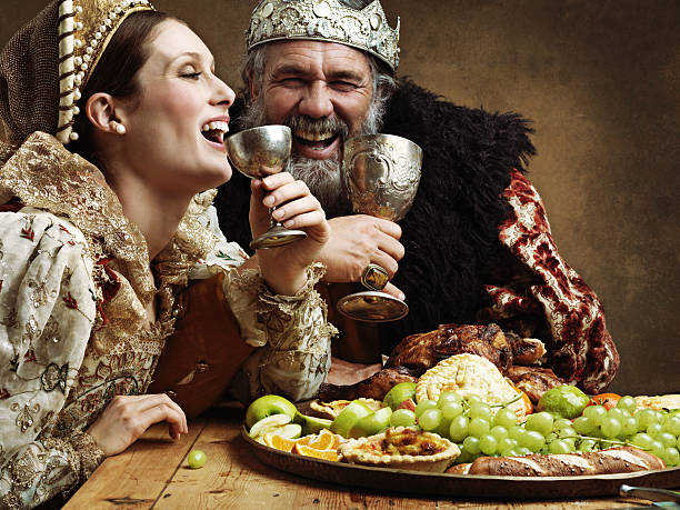 Mead and merriment A mature king feasting alone in a banquet hall banquet stock pictures, royalty-free photos & images