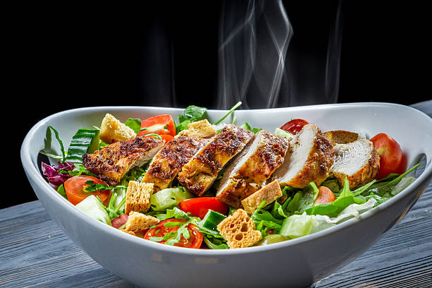Meal consisting of grilled chicken pieces and salad Hot chicken and fresh vegetables in healthy salad. chicken salad stock pictures, royalty-free photos & images