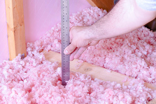 Measuring Attic Energy Efficiency Clean work, checking the energy efficiency of their house by measuring the thickness of fiberglass insulation in the attic insulation stock pictures, royalty-free photos & images