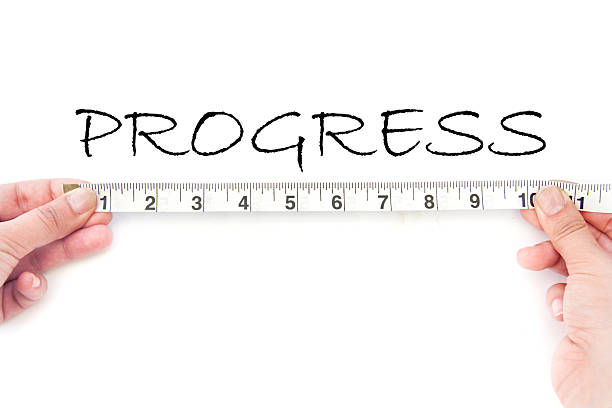 Measuring progress Tape measure aligned against the word progress handwritten on a whiteboard measure progress stock pictures, royalty-free photos & images