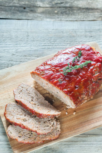 Meat loaf covered with tomato sauce Meat loaf with tomato sauce on the wooden board meat loaf stock pictures, royalty-free photos & images
