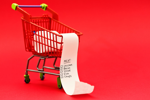 A miniature supermarket trolley contains a list headed Meat; someone's planning a high-protein diet. 