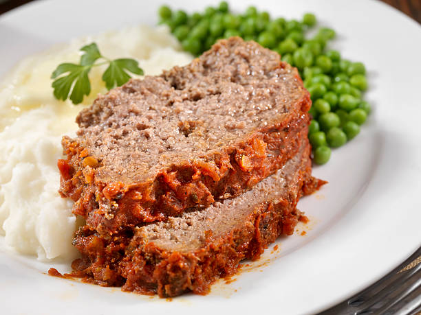Meatloaf Baked In Tomato Sauce Meatloaf Baked In Tomato Sauce with Mashed Potatoes and Green Peas -Photographed on Hasselblad H3D2-39mb Camera meat loaf stock pictures, royalty-free photos & images