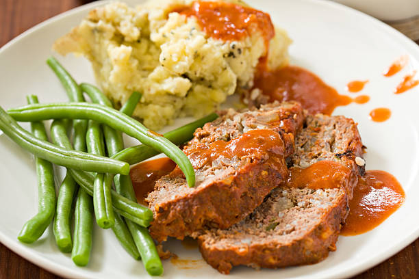 Meatloaf Dinner "A close up shot of a meatloaf dinner, two slices of meatloaf, skin on mashed potatoes, lightly steamed green beans and a tomato sauce." meatloaf stock pictures, royalty-free photos & images