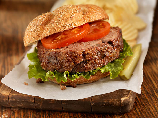 Meatloaf Sandwich Meatloaf Sandwich with Lettuce and Tomato a Dill Pickle and Potato Chips -Photographed on Hasselblad H3D2-39mb Camera meat loaf stock pictures, royalty-free photos & images