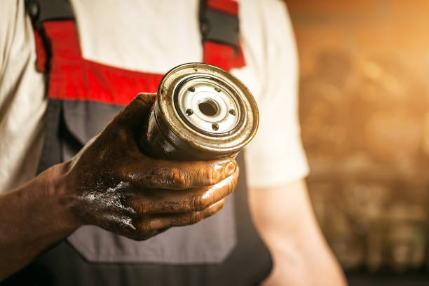 Mechanic. Dirty hands holding oil filter. stock photo