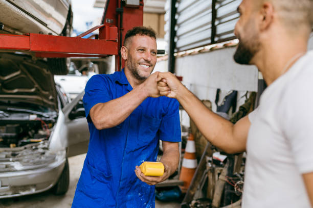 Mechanic greeting customer after credit card payment stock photo
