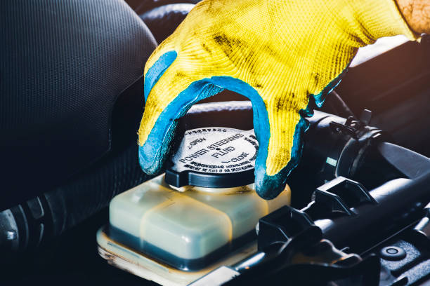 Mechanic hand is open or close the cap of the power steering fluid stock photo