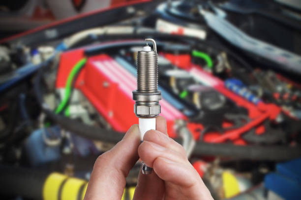 Mechanic holds a spare part spark plug in hand stock photo