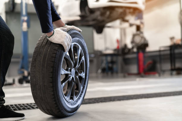 mechanic man change a wheel tire and service maintenance the suspension of a vehicle , safety inspection test engine before customer drive a car on a long journey, transportation service - car garage imagens e fotografias de stock