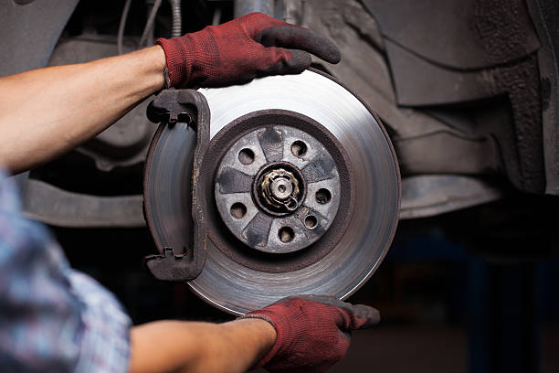 Mechanic repairing brakes on a car Repairing brakes on car brake stock pictures, royalty-free photos & images