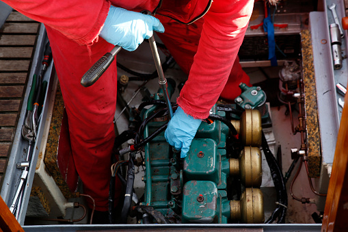 A service engineer fixing the engine of a  vessel