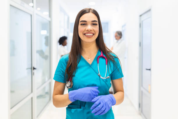 Medical concept of beautiful female doctor with stethoscope, waist up. Medical student. Woman hospital worker looking at camera and smiling, hospital background stock photo