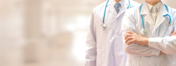 Medical healthcare doctor team concept. Physicians in white gown and stethoscope, hand holding computer tablet on blur background corridor hospital for copy space. Medical healthcare doctor team concept. Physicians in white gown and stethoscope, hand holding computer tablet on blur background corridor hospital for copy space. generic drug stock pictures, royalty-free photos & images