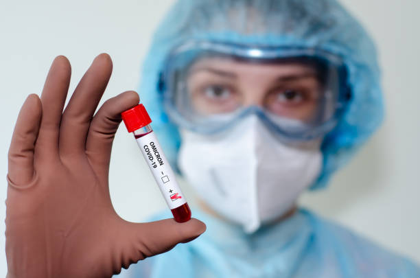 medical laboratory assistant holding test tube with positive omicron covid-19 test blood sample. - omicron covid stok fotoğraflar ve resimler
