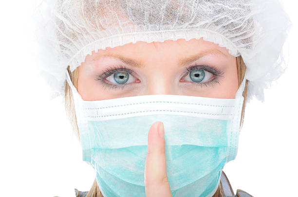 Medical professional showing the sign for silence stock photo