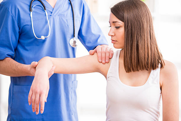 Medical services Doctor and patient - examination of the arm and elbow. orthopedics stock pictures, royalty-free photos & images