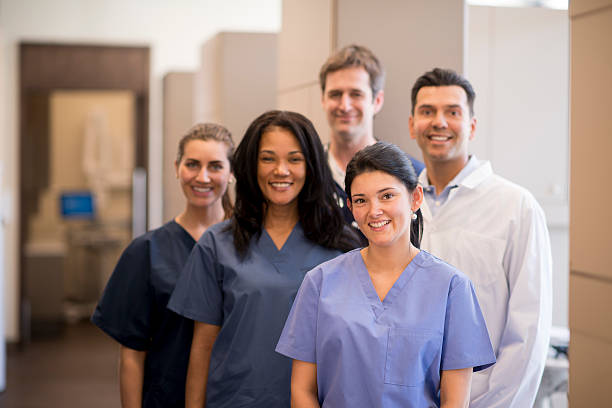 Medical Setting Office A group of doctors, nurses, and or dentists and professional assistants posing for a picture in a medical clinic. assistant stock pictures, royalty-free photos & images